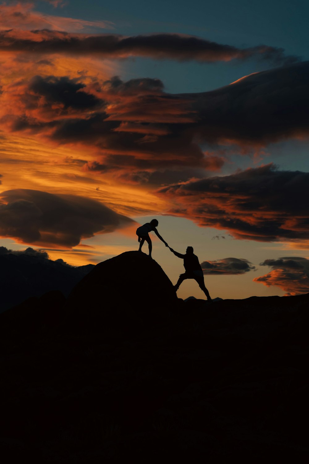 um casal de pessoas de mãos dadas no topo de uma colina