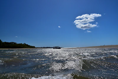 A scenic coastal view with a small boat and clear blue water.