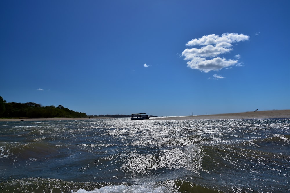 a boat traveling down a river under a blue sky