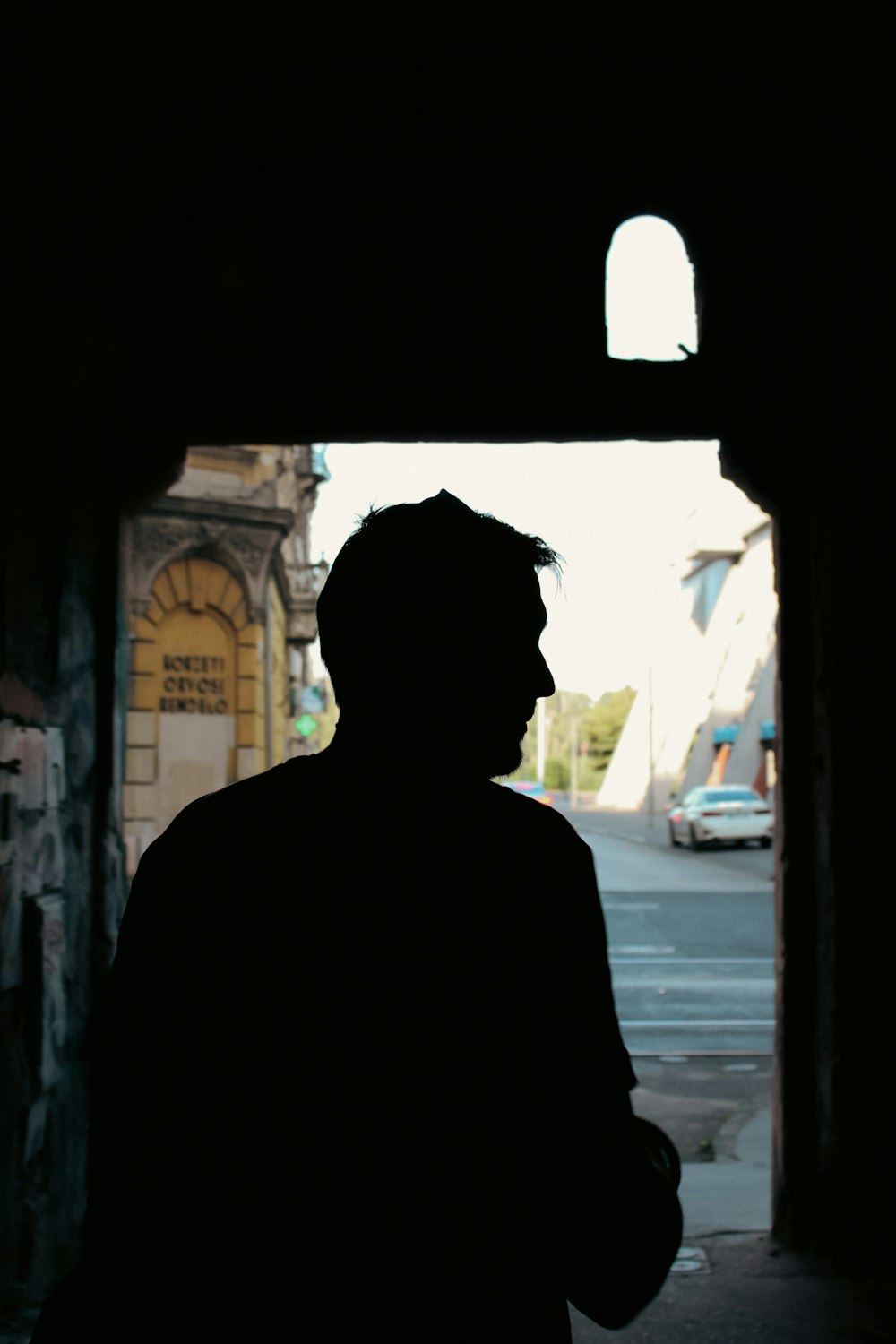 a silhouette of a man standing in a tunnel