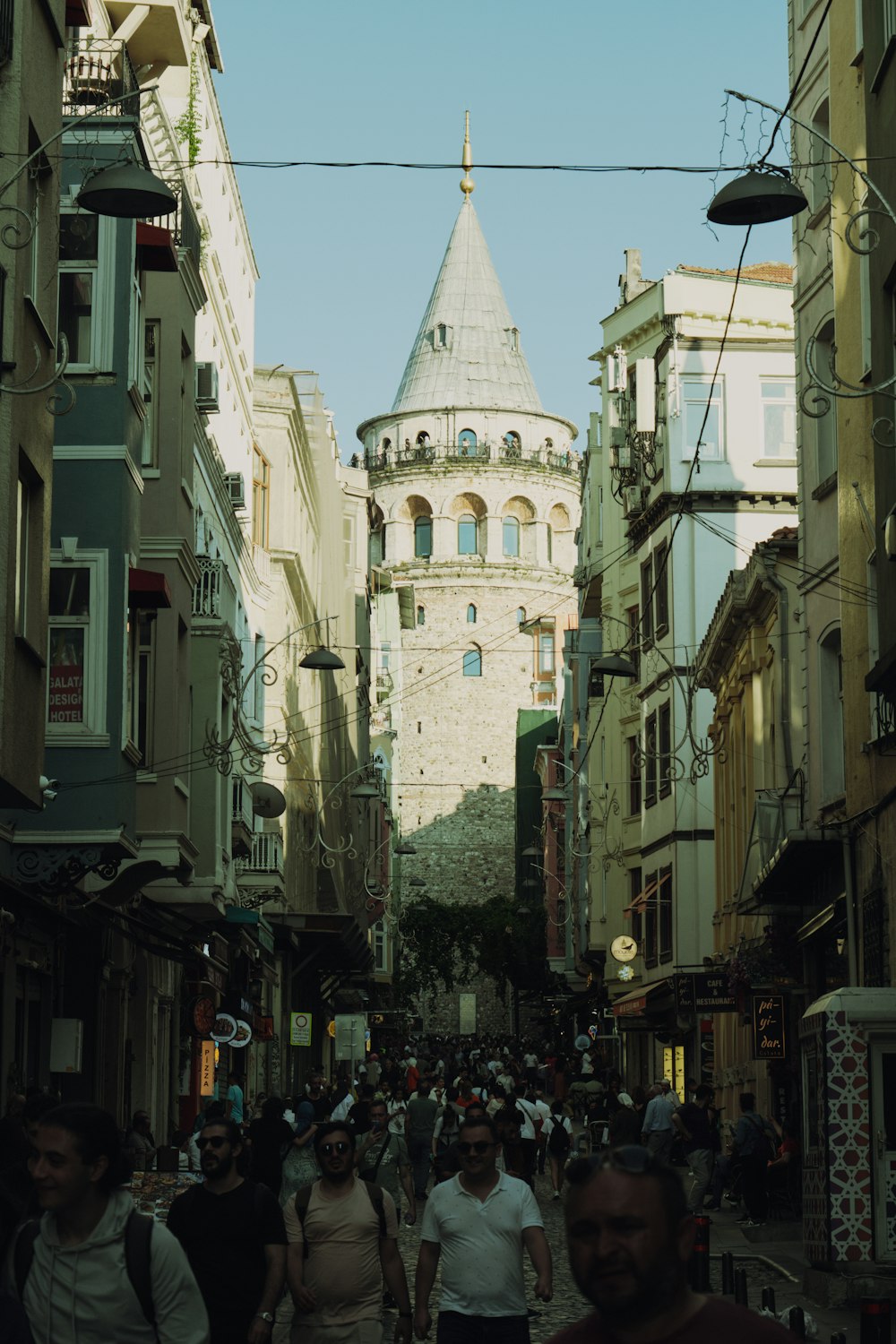 a group of people walking down a street next to tall buildings