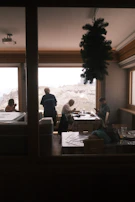 Family enjoying a meal in the scenic restaurant area with large windows framing mountains.