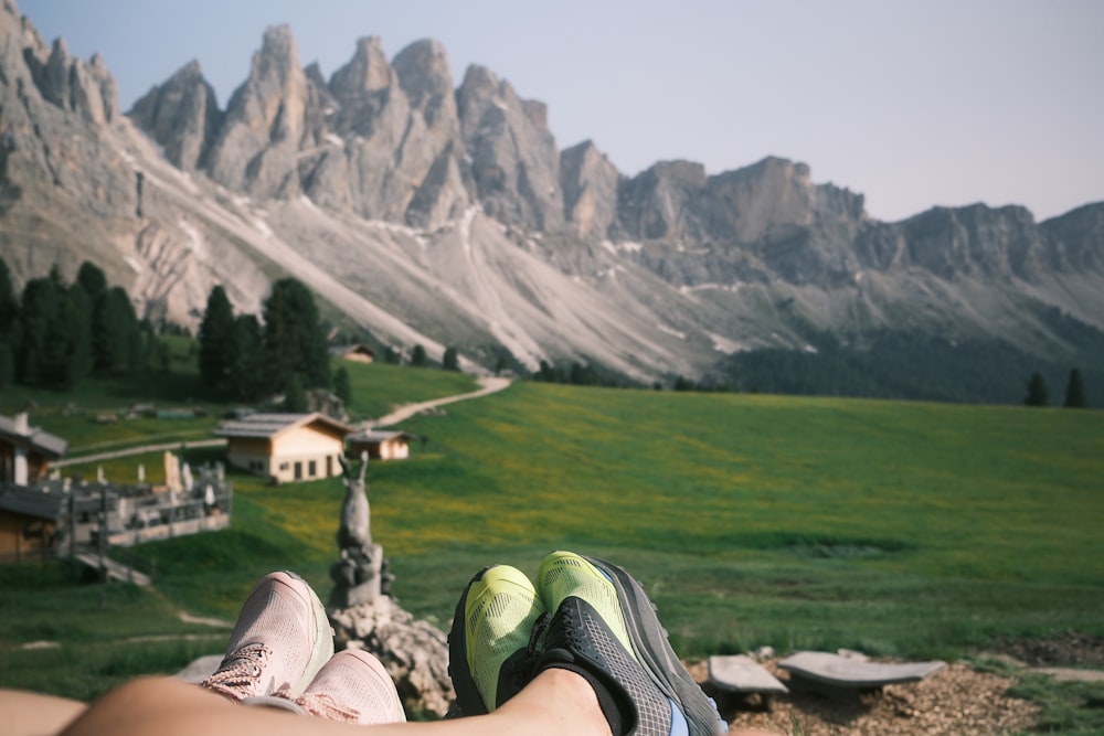 Un par de pies descansando sobre una roca frente a una cadena montañosa