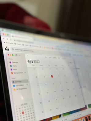 A computer screen displaying a digital calendar for July 2023. The screen shows a sidebar with calendar categories such as Home, Work, and Birthdays. The days of the month are displayed in a grid format, and the calendar is part of an application interface with browser icons visible at the top.