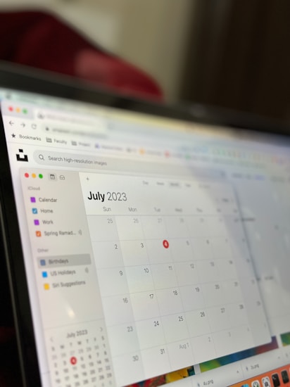 A computer screen displaying a digital calendar for July 2023. The screen shows a sidebar with calendar categories such as Home, Work, and Birthdays. The days of the month are displayed in a grid format, and the calendar is part of an application interface with browser icons visible at the top.