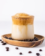 a cup of coffee on a plate with coffee beans
