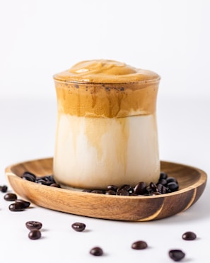 a cup of coffee on a plate with coffee beans