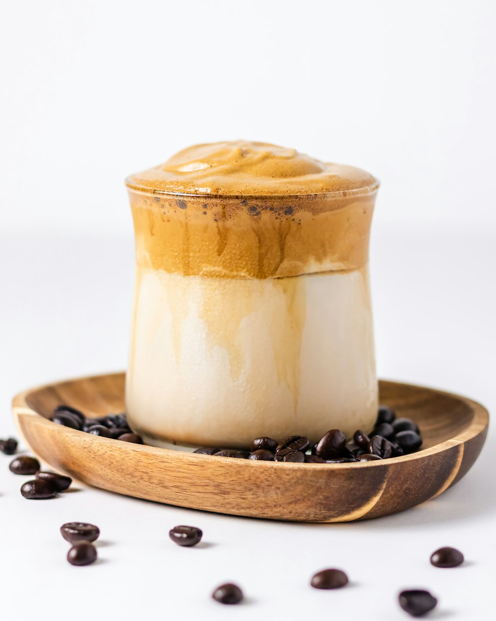 a cup of coffee on a plate with coffee beans