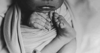 a black and white photo of a woman holding a baby