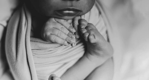 a black and white photo of a woman holding a baby