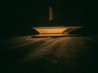 A warm, inviting night scene showing a person using a laptop softly illuminated in a cozy room.