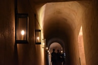 A candlelit hallway with stone walls, evoking the secretive atmosphere of the donjon.