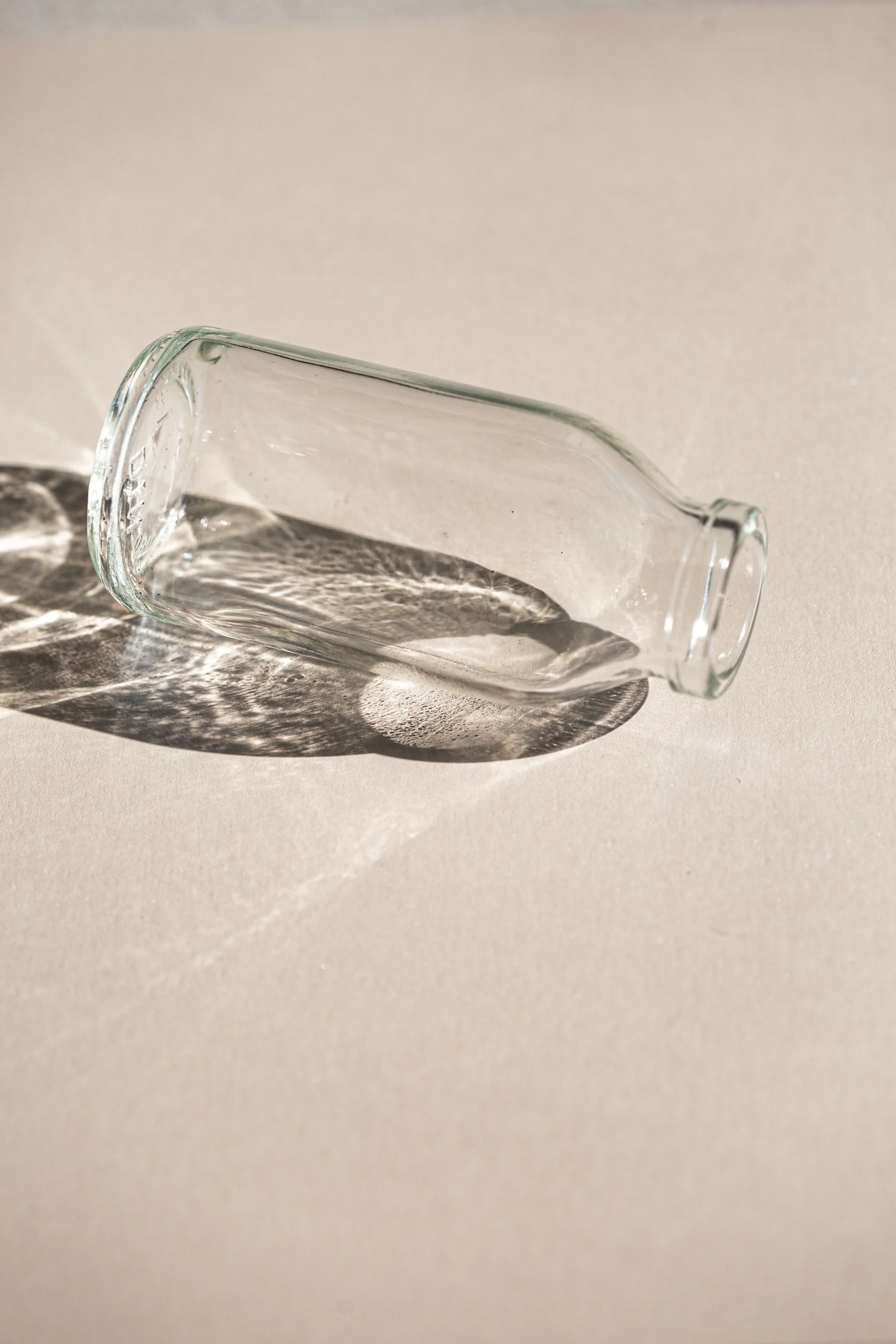 A glass bottle casting a soft shadow