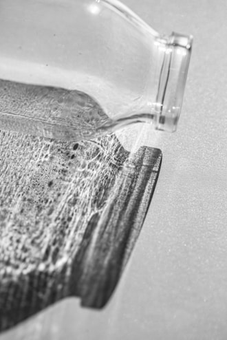 Close-up of an antique glass bottle with intricate patterns reflecting warm light.