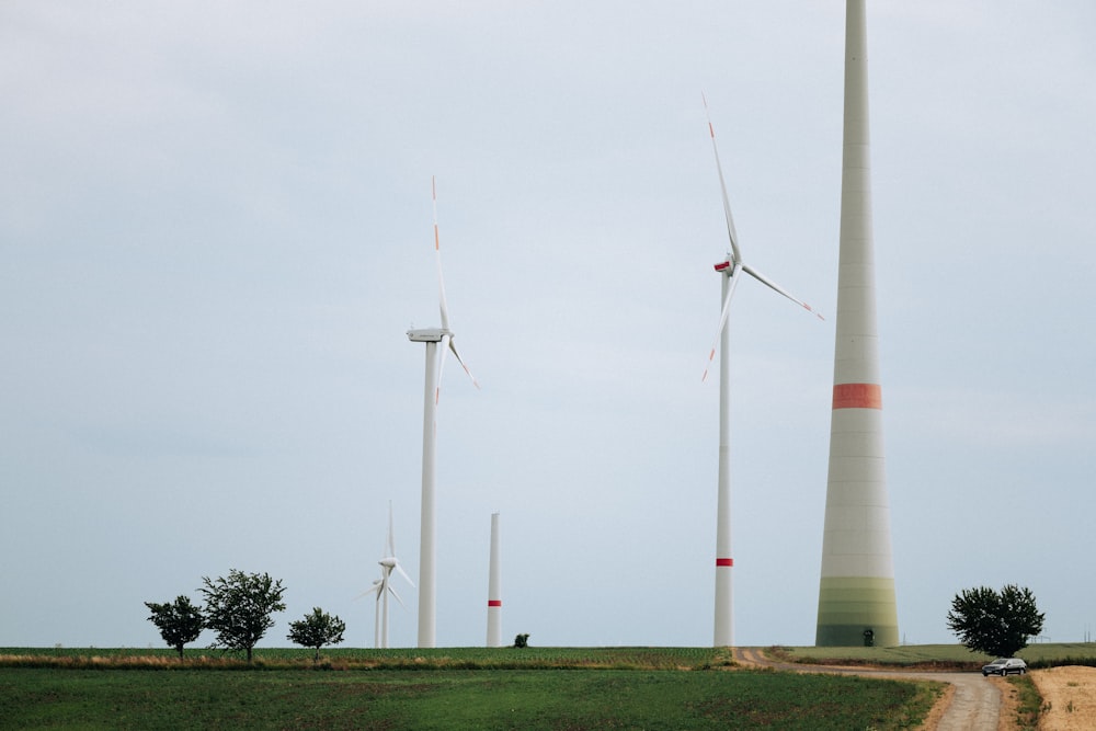 a group of windmills in a field near a dirt road