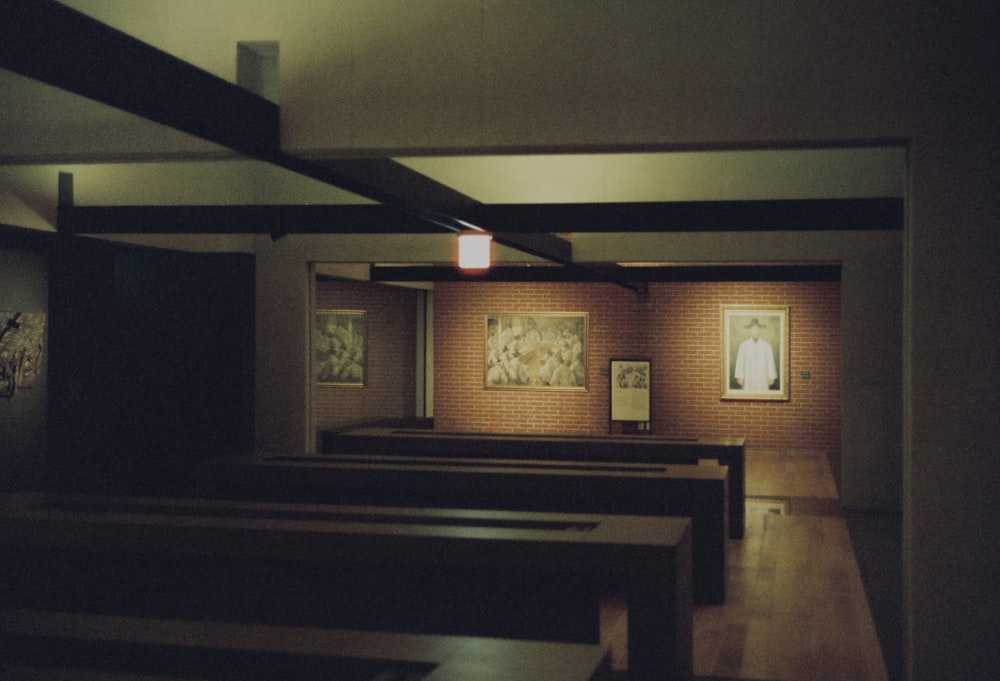 a dimly lit room with benches and pictures on the wall