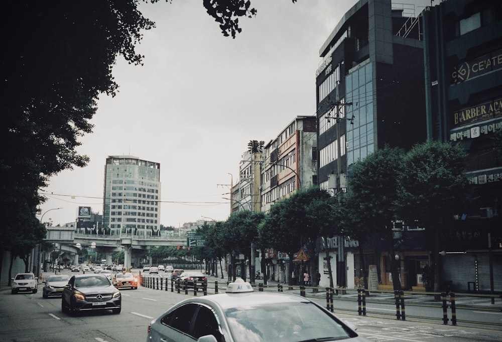 a car driving down a street next to tall buildings