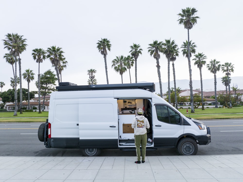 a man standing in front of a white van