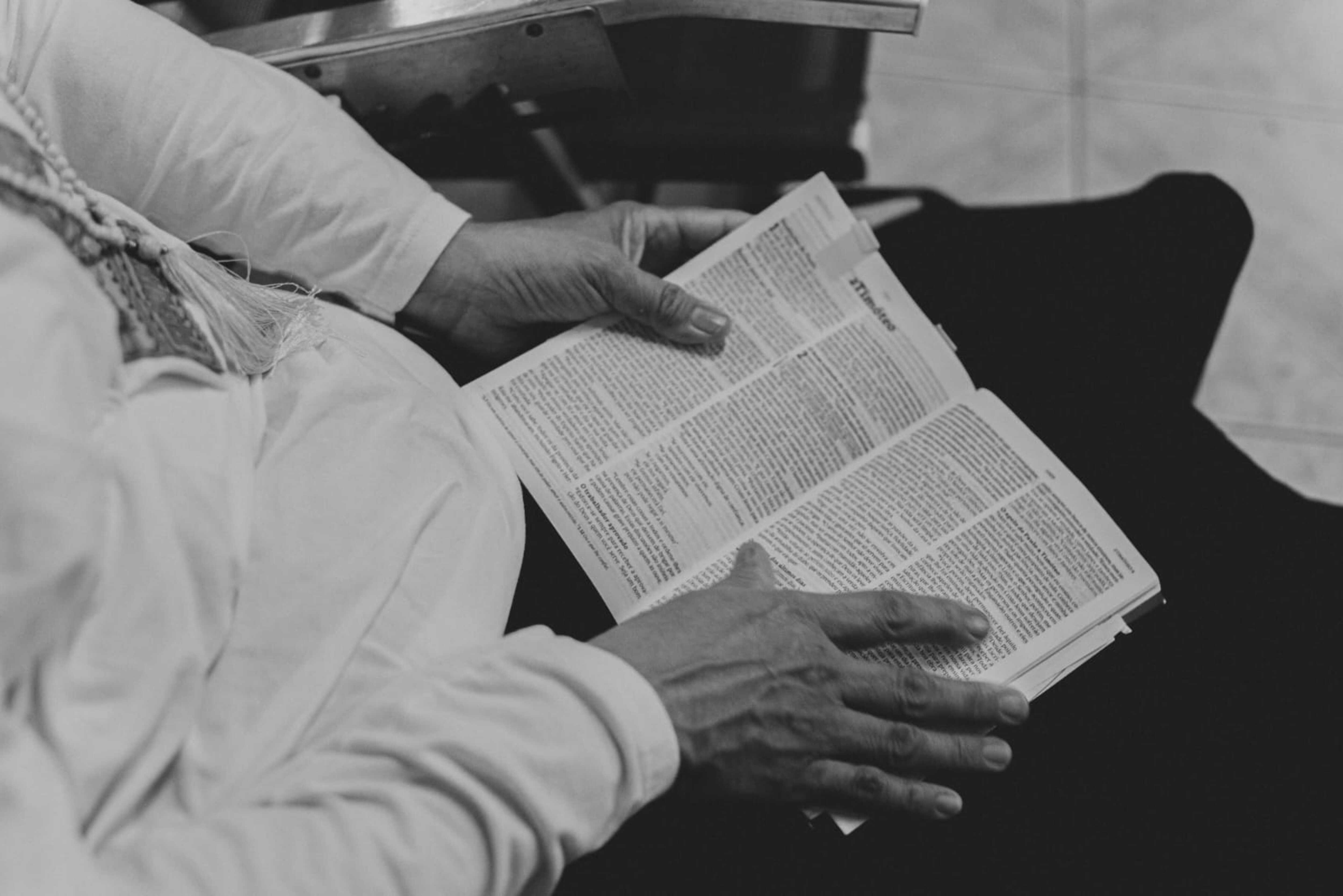 a black and white photo of a person reading a book