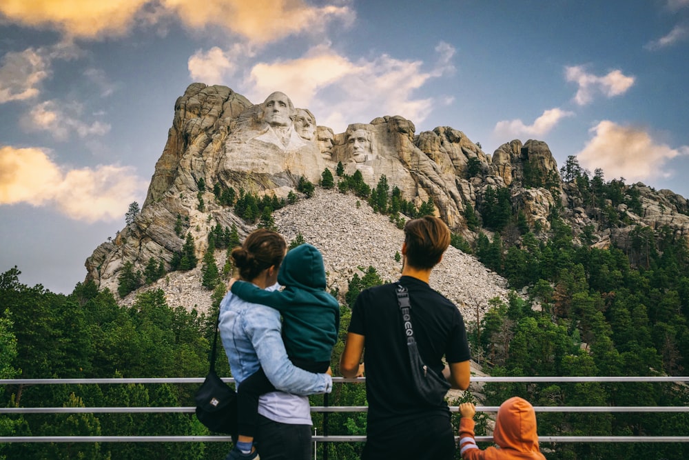 two people and a child looking at a mountain