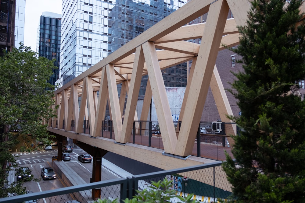 a wooden bridge over a busy city street