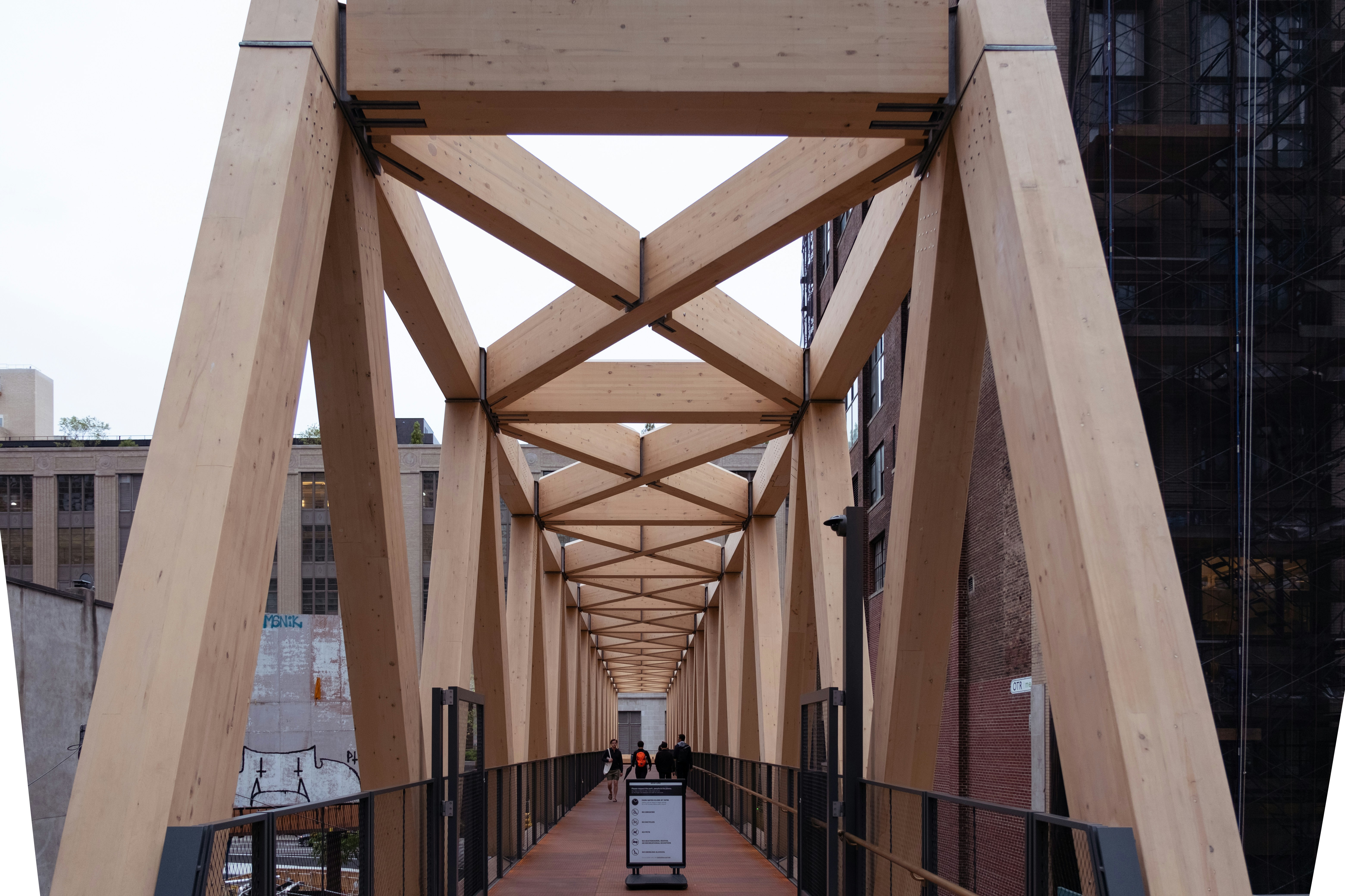 a long wooden walkway in a city with tall buildings