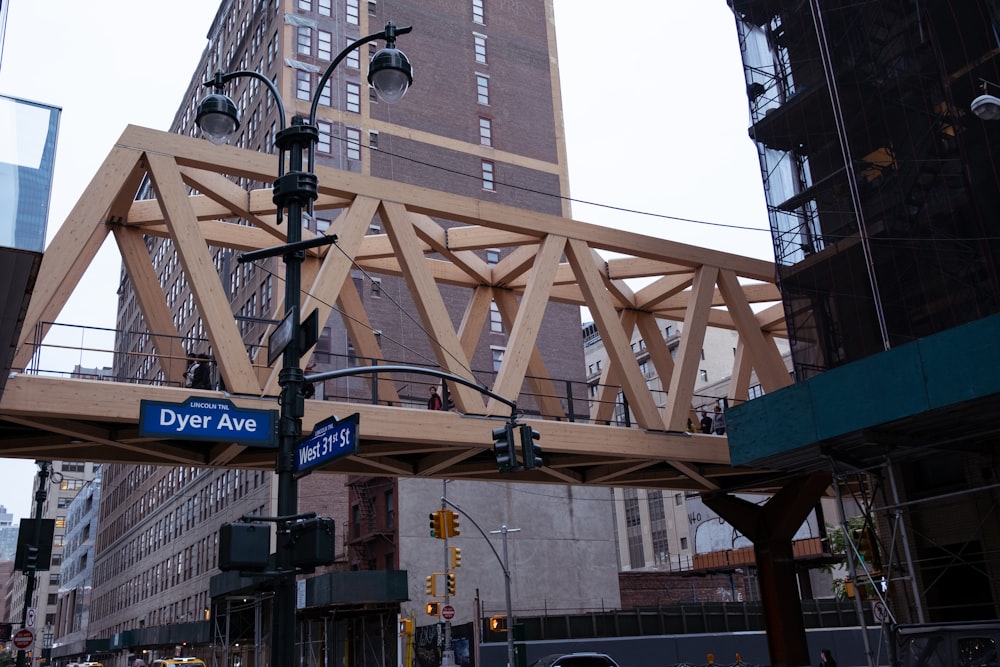 a wooden bridge over a busy city street