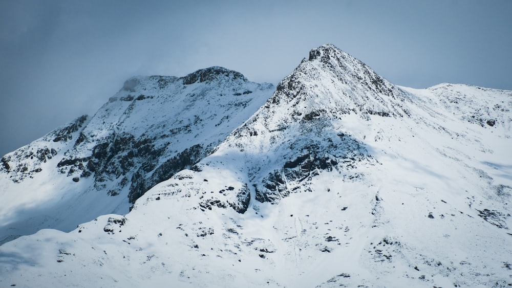 a mountain covered in snow with a sky background