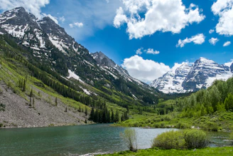 Tourists enjoying a peaceful stop at Tsomgo Lake with snow-capped peaks in the background
