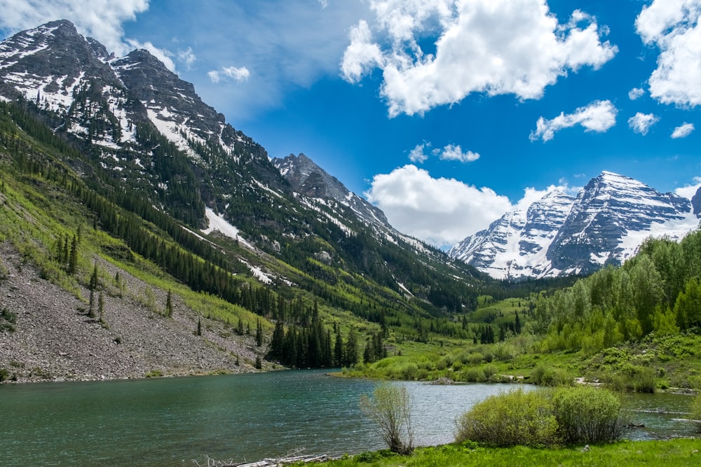 a beautiful mountain scene with a river in the foreground