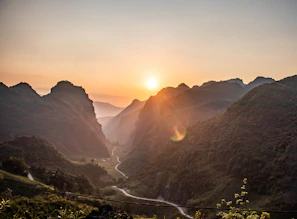 A serene sunrise over a misty mountain road in Europe, perfect for vanlife adventures.