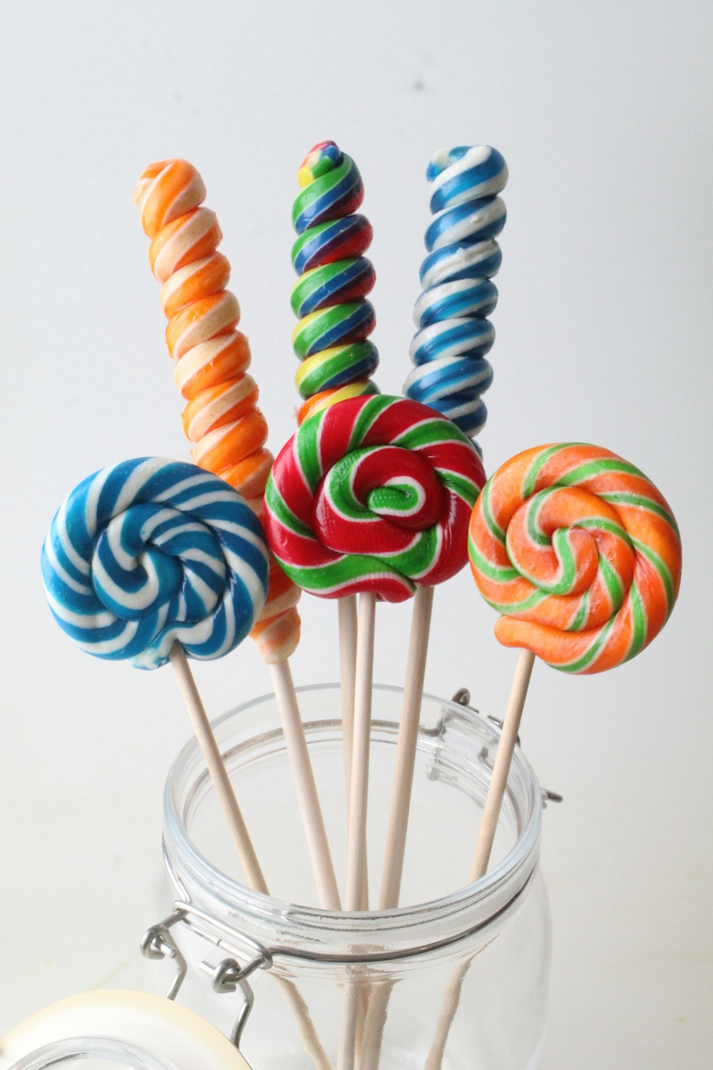 colorful lollipops in a glass jar on a table