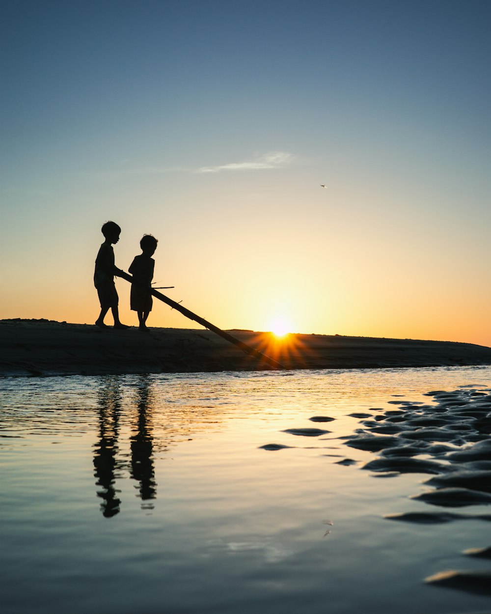 a couple of people standing on top of a beach