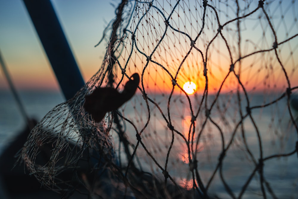 a fishing net with the sun setting in the background