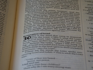 A close-up of an open book displaying text. The page contains a chapter titled 'Restoration of Israel' with a section numbered 30. The text is in English and formatted in paragraphs, with some words in bold to denote headings or sub-sections.
