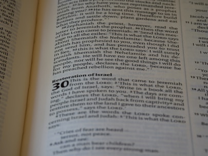 A close-up of an open book displaying text. The page contains a chapter titled 'Restoration of Israel' with a section numbered 30. The text is in English and formatted in paragraphs, with some words in bold to denote headings or sub-sections.