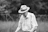 an old man wearing a hat and holding a tennis racquet