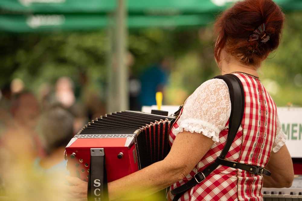 a woman in a red and white dress playing an accordion