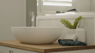 Close-up of a handcrafted tile sink with natural stone textures in a minimalist modern bathroom.