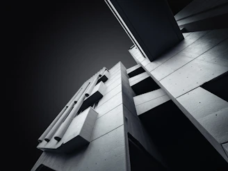 Close-up of a sleek concrete building facade with sharp geometric shapes.