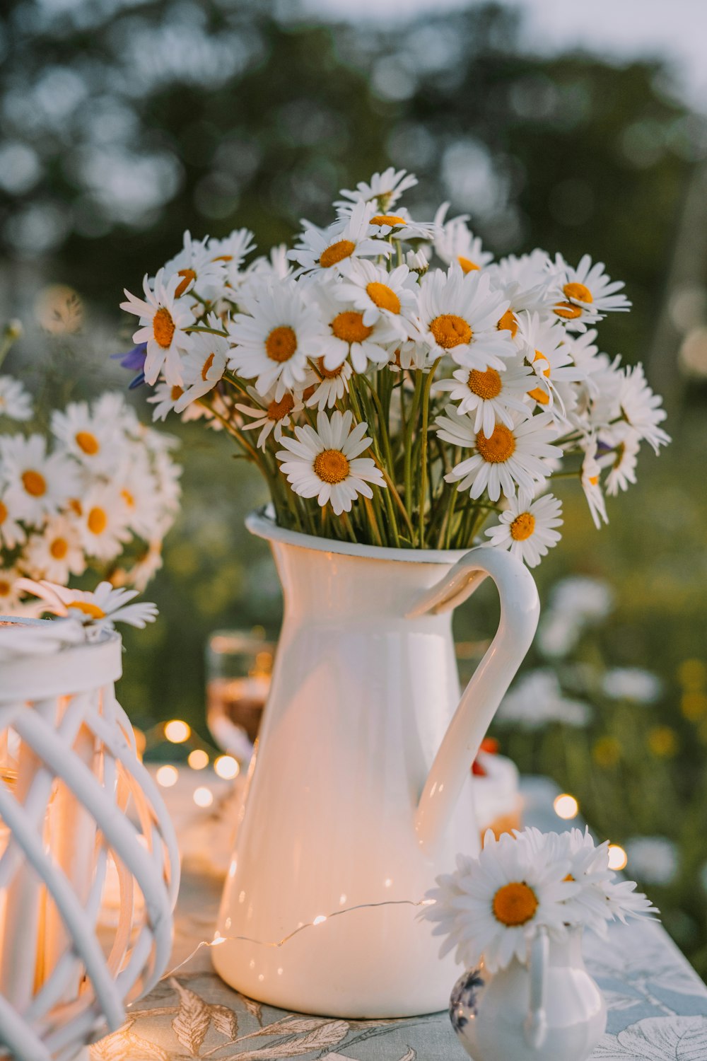 a white vase filled with daisies sitting on top of a table