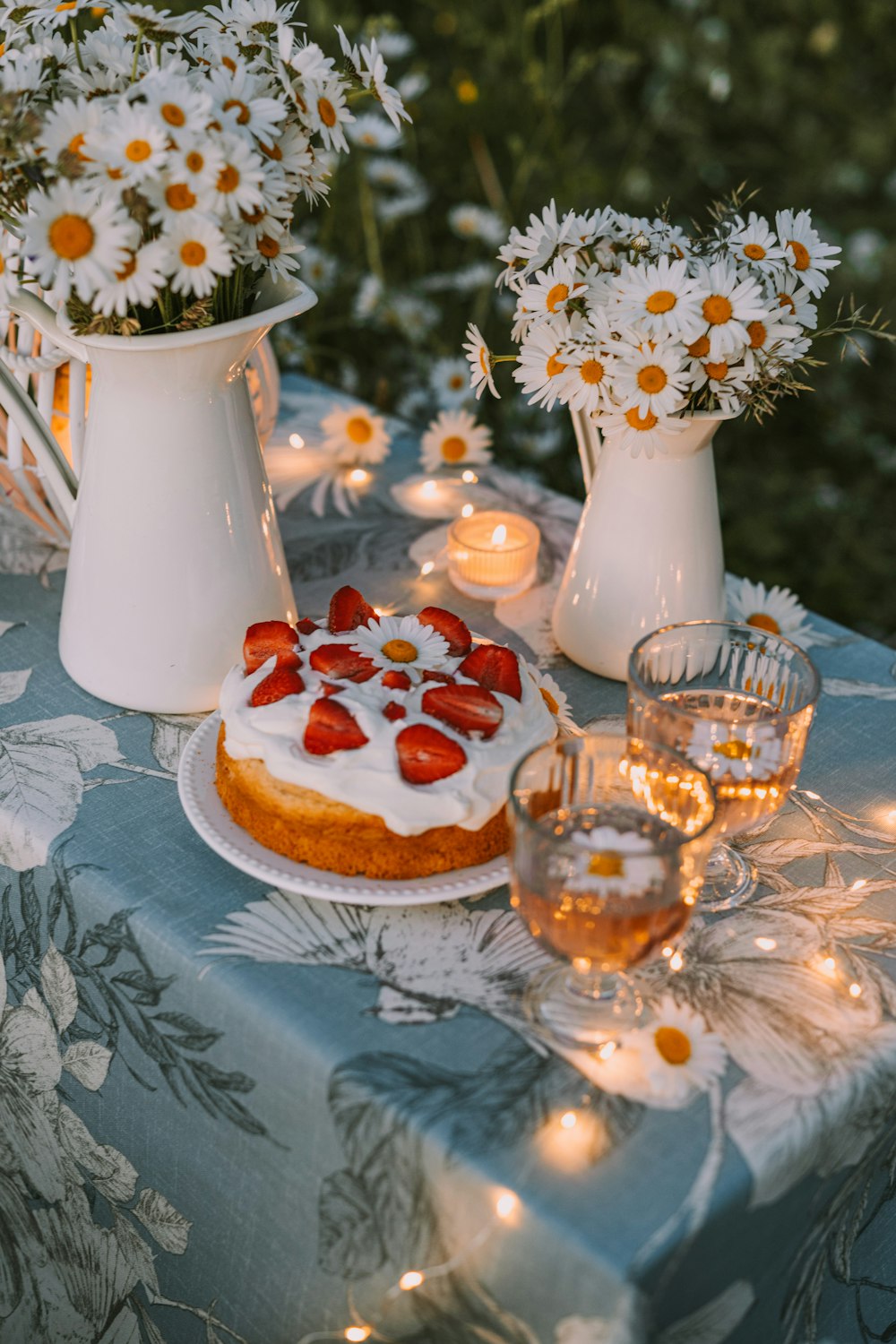 a table topped with a cake covered in strawberries