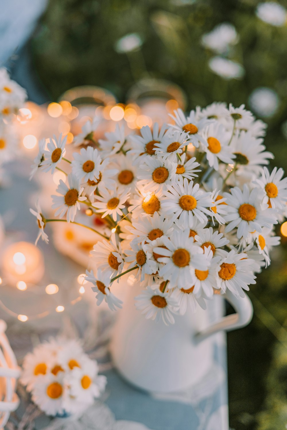 a vase filled with white daisies sitting on top of a table