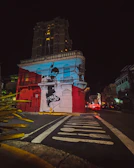 A vibrant snapshot of a colorful street mural under glowing evening lights.
