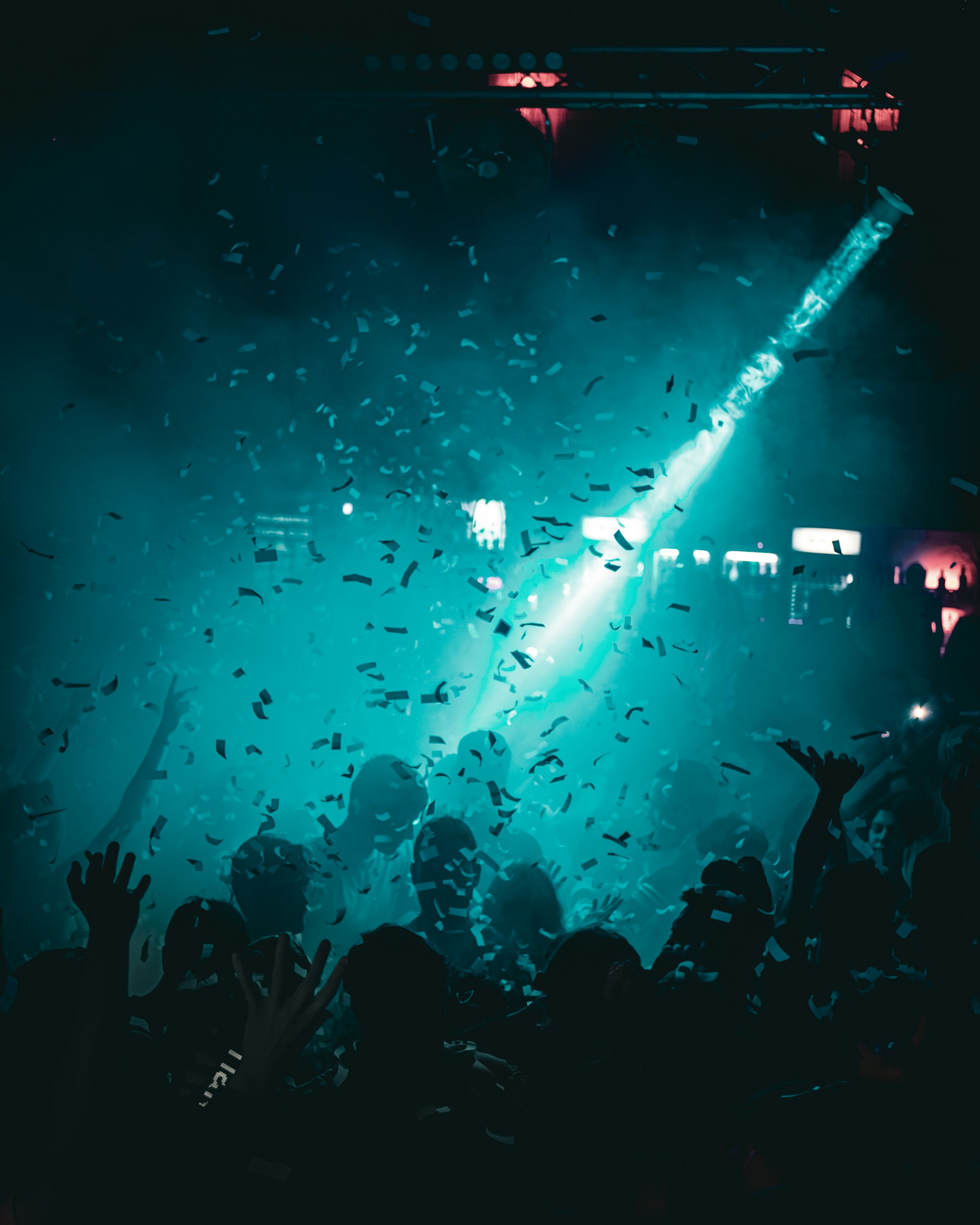 a crowd of people at a concert with their hands in the air