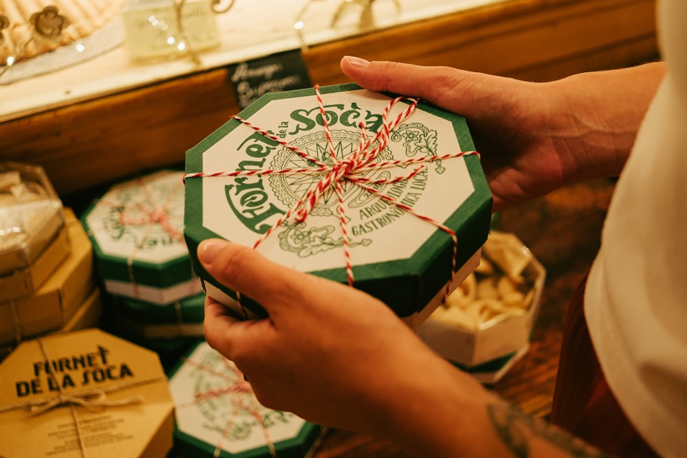 a person holding a green and white gift box