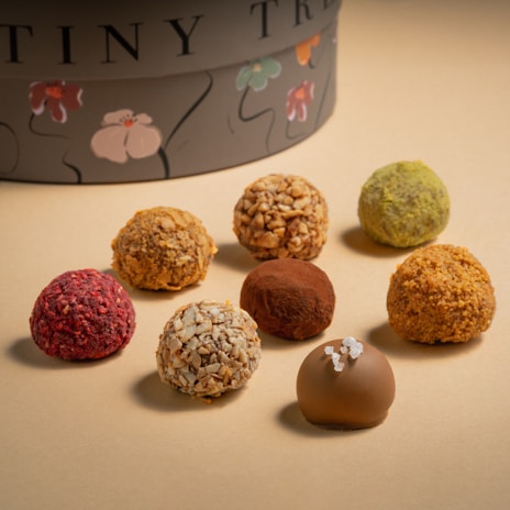 Close-up of glossy truffles with unique toppings like crushed nuts and edible flowers