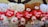 Several plush teddy bears are arranged in a row, each holding a red heart with 'I Love You' written on it. The bears are primarily in shades of white and brown, with red accents on their noses and paws, creating a cozy and affectionate display.