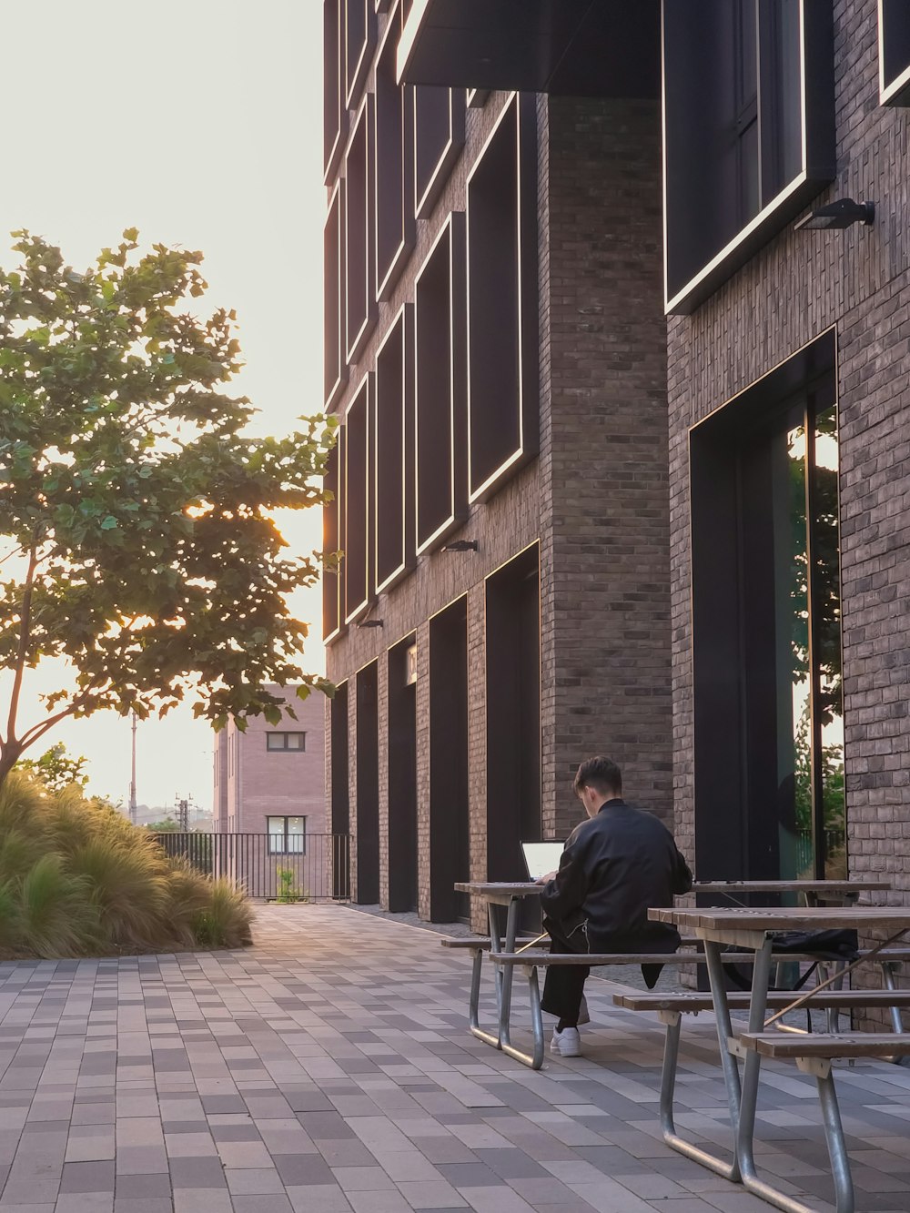 a man sitting on a bench in front of a building