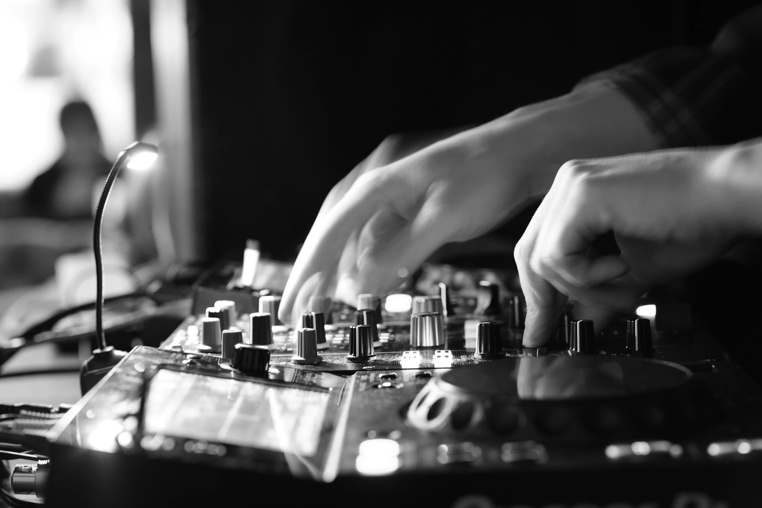 Hands adjusting a DJ mixer